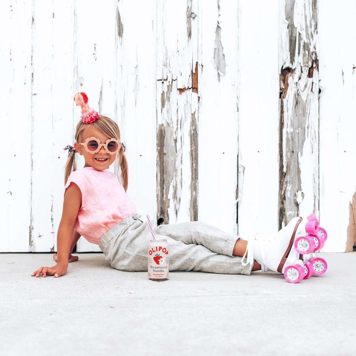 little blonde girl in roller skates wearing pink linen top and green linen pants