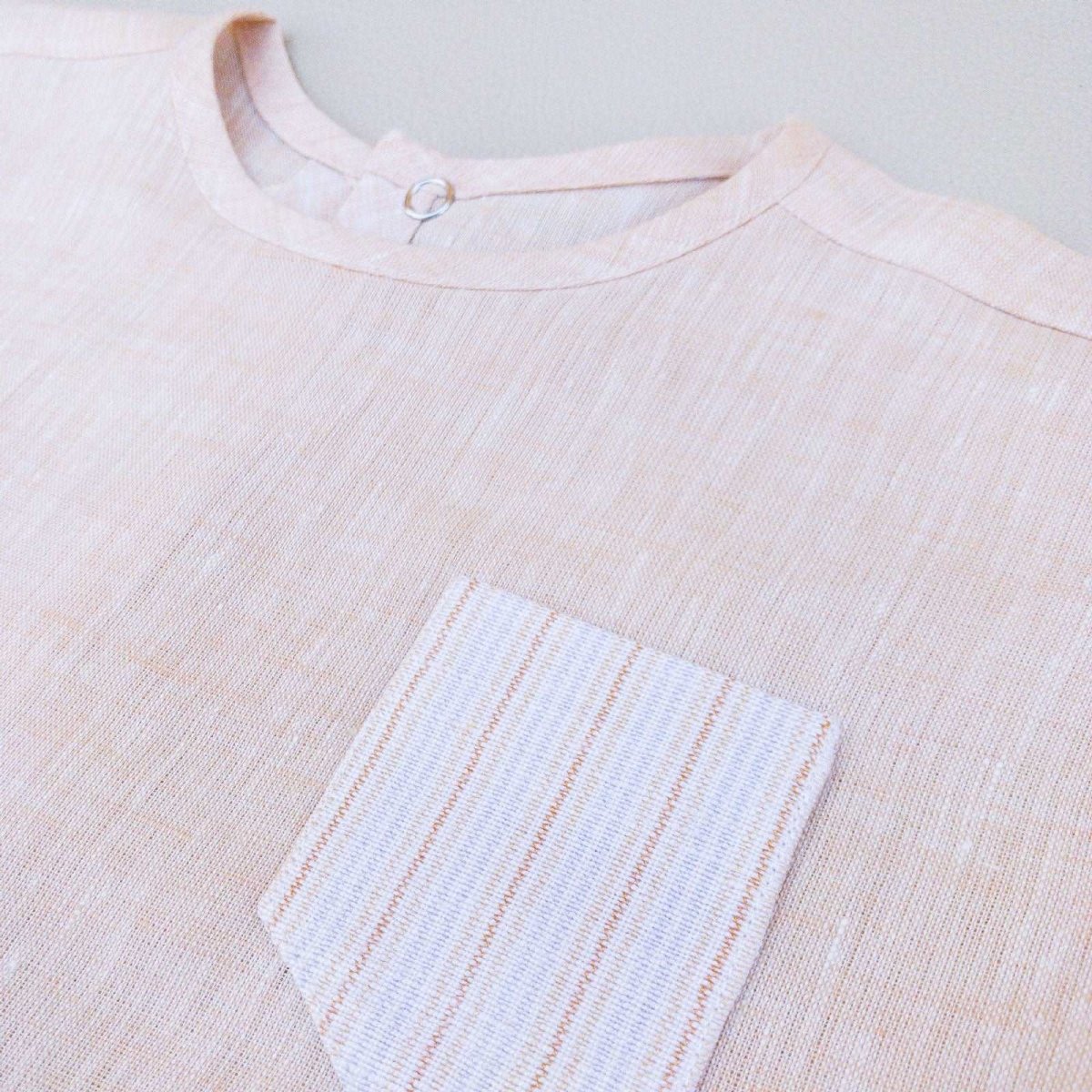 detail view of Beya Made pale pink linen baby/toddler top shown flat